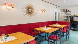 A restaurant with red upholstered booths, wooden tables, and wall-mounted lamps. - Room 14 (double room) with mountain view, balcony and Wi-Fi (Seefeld in Tirol)