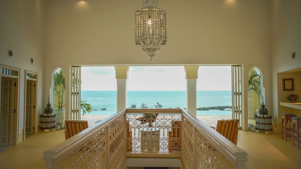 A spacious balcony with a view of the ocean, a chandelier, and traditional decor. - Riad Lamp (Nanjo)