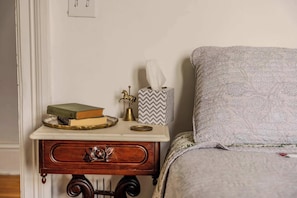 A bedside table with a book, a tissue box, and a decorative item.