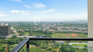 Een hoog gebouw met uitzicht op een stadsgezicht, inclusief woonwijken en groen.