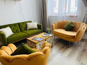 A modern living room with a green sofa, a yellow armchair, and a wooden coffee table.