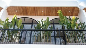 Un bâtiment moderne doté d’un plafond en bois et d’un balcon agrémenté de grandes plantes.