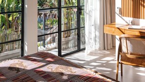 A modern room with large windows, a wooden desk, and a patterned rug. - the macan Canggu (Canggu)