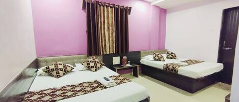 A hotel room with two beds, a nightstand, a coffee maker, and a window with curtains.
