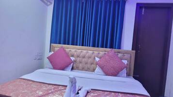 Una cama bien hecha con una colcha estampada, dos almohadas y un par de toallas dobladas sobre la cama.