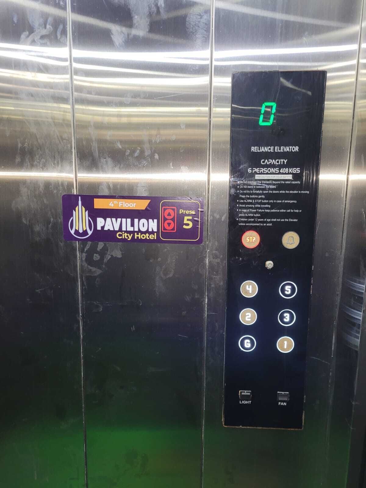 An elevator control panel with a capacity sign for 6 persons and 408 kgs, a 4th floor indicator, and a 'Press 5' button.