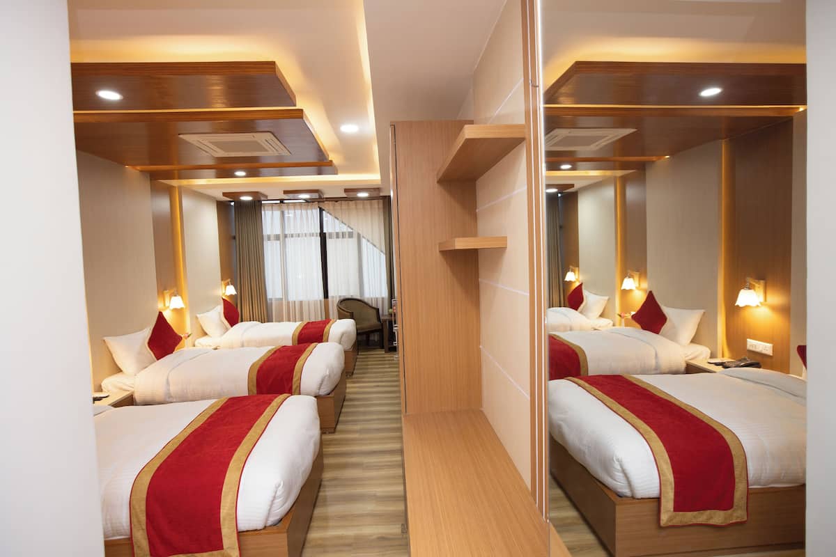 A hotel room with two beds, wooden headboards, and a mirror on the wall.