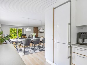 A modern kitchen with white cabinets and stainless steel appliances.