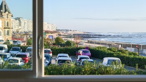A coastal cityscape with a parking lot, buildings, and a view of the ocean. - Sea-facing apartment - 5 people (Les Sables-d´Olonne)