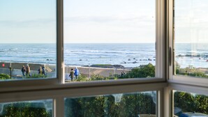 A view through a window of a coastal area with people walking along a path near the water. - Sea-facing apartment - 5 people (Les Sables-d´Olonne)