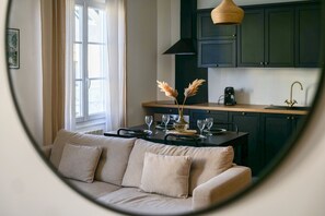 Une cuisine moderne avec des meubles de couleur sombre, un plan de travail en bois et un luminaire suspendu.