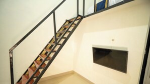 A staircase with a metal frame and wooden steps leading to a landing. - CQA Living By ARBA (Jakarta)
