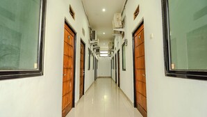 A hallway with wooden doors and air conditioning units on the walls. - CQA Living By ARBA (Jakarta)