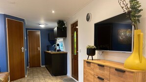 A modern kitchen with a built-in stove, a black countertop, and a wooden cabinet. - Atmospheric Chalet Near the Wadden Sea (Tzummarum)