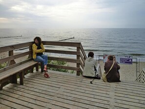 A wooden pier with benches overlooking a body of water. - Comfortable Apartment Close to the Beach (Ustronie Morskie)