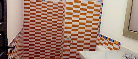 A bathroom with checkered tile walls, a sink, and a toilet.