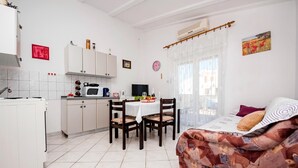 A compact living space with a kitchenette, dining area, and a sofa with a patterned cover. - Apartment in Rovinj near Fantasia Monfiorenzo (Rovinj)