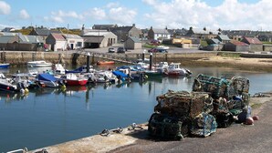 A harbor with boats docked and fishing gear on the shore. - The Corner House -  a house that sleeps 10 guests  in 4 bedrooms (Hopeman)