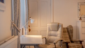 A room with a white door, a desk with a lamp, and two chairs. - Cosy Garden Cottage | Fleming Place (St Andrews)