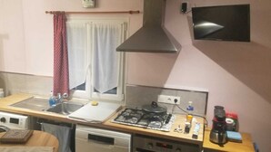 Cocina compacta con estufa, pileta y microondas.