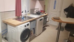 Una cocina funcional con lavadora, estufa y lavamanos.