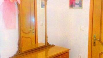 A wooden dresser with a mirror and a door.