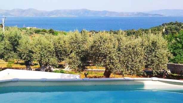 A swimming pool with a view of the sea and mountains in the background. - Villa Konaki (Grammatiko)