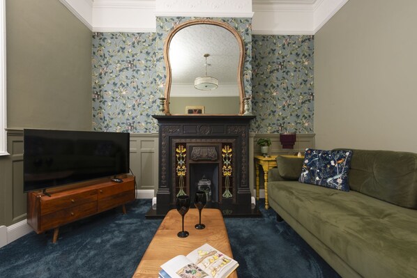 A living room with a fireplace, a television, a sofa, and a coffee table.