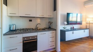 A modern kitchen with white cabinets, a gas stove, and a sink. - Modern downtown apartment with panoramic view of St. Peter's dome (Roma)