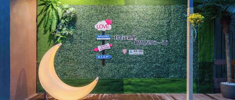 A room with a green wall, a crescent moon decoration, and a signpost with various messages.