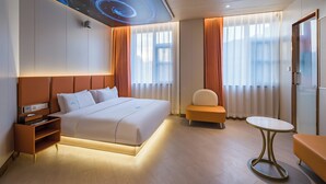 A modern hotel room with a large bed, a small table, a sofa, and a ceiling with a galaxy design. - Dequan Luxury Hotel  (Beijing)