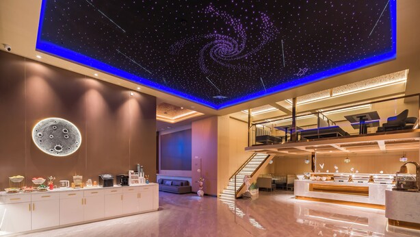 A modern hotel lobby with a starry ceiling, a round moon decoration, and a reception desk. - Dequan Luxury Hotel  (Beijing)