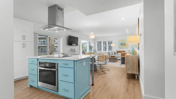 A modern kitchen with a central island, white cabinetry, and a built-in oven. - Fun and Sun 2nd Floor Oceanview 3 Bedroom (Pawleys Island)
