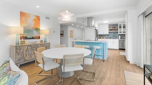 A modern kitchen with white cabinets, a blue island, and a hanging light fixture. - Fun and Sun 2nd Floor Oceanview 3 Bedroom (Pawleys Island)