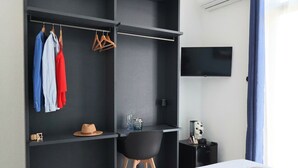 A modern bedroom with a bed, a desk, a wardrobe, and a TV.