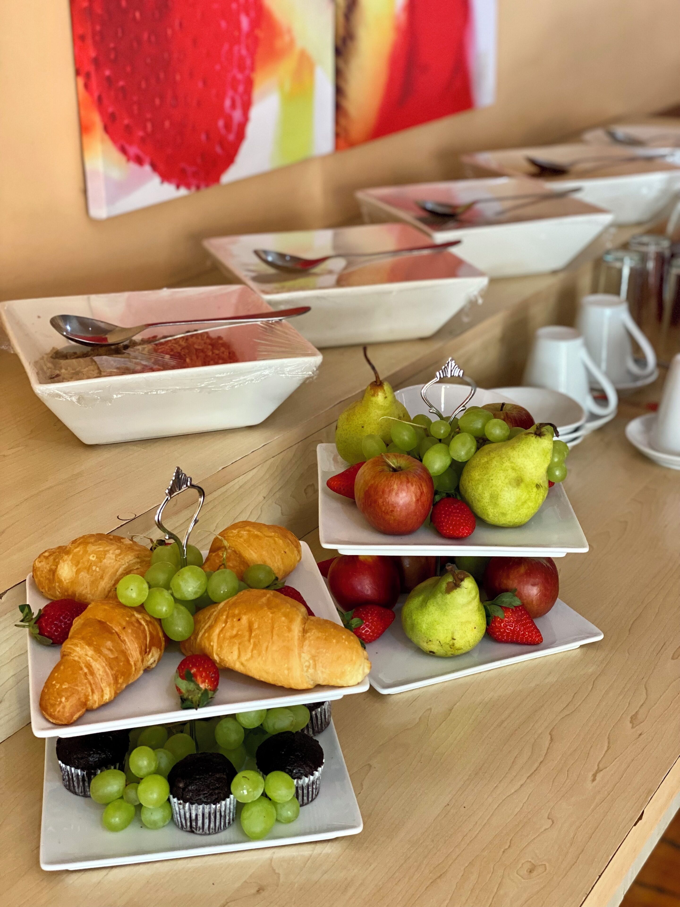 A breakfast buffet with various food items and utensils.