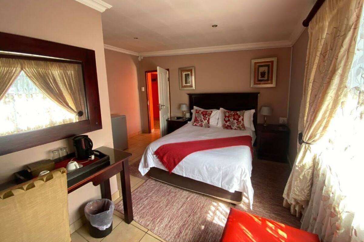 Een hotelkamer met een bed, nachtkastje en een televisie.