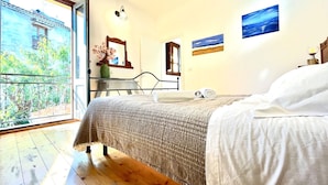 Una camera da letto con un'ampia finestra, un letto, una scrivania e una sedia.