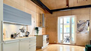 A modern kitchen with a large window, wooden flooring, and a minimalist design. - Unique Design House in Downtown Oslo (Oslo)