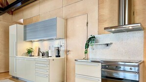 A modern kitchen with white cabinetry, a stainless steel range hood, and a tiled backsplash. - Unique Design House in Downtown Oslo (Oslo)