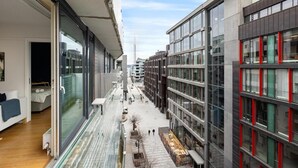 Ein modernes Gebäude mit großen Fenstern, einer Glasfassade, einem schmalen Fußweg und Blick auf die Stadtlandschaft.