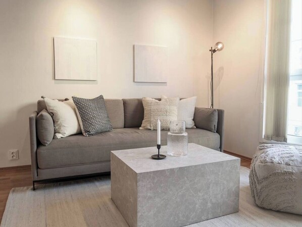 A modern living room with a grey sofa, a coffee table, and a floor lamp.