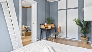 A bedroom with a bed, a desk with a chair, a wardrobe, and a plant. - Big and Bright Apartment in the Center (Oslo)