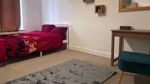 A bedroom with a bed, a desk, a chair, and a window with curtains. - 1br-sleeps4-35mintocentrallondon-40mintoheathrow (London)