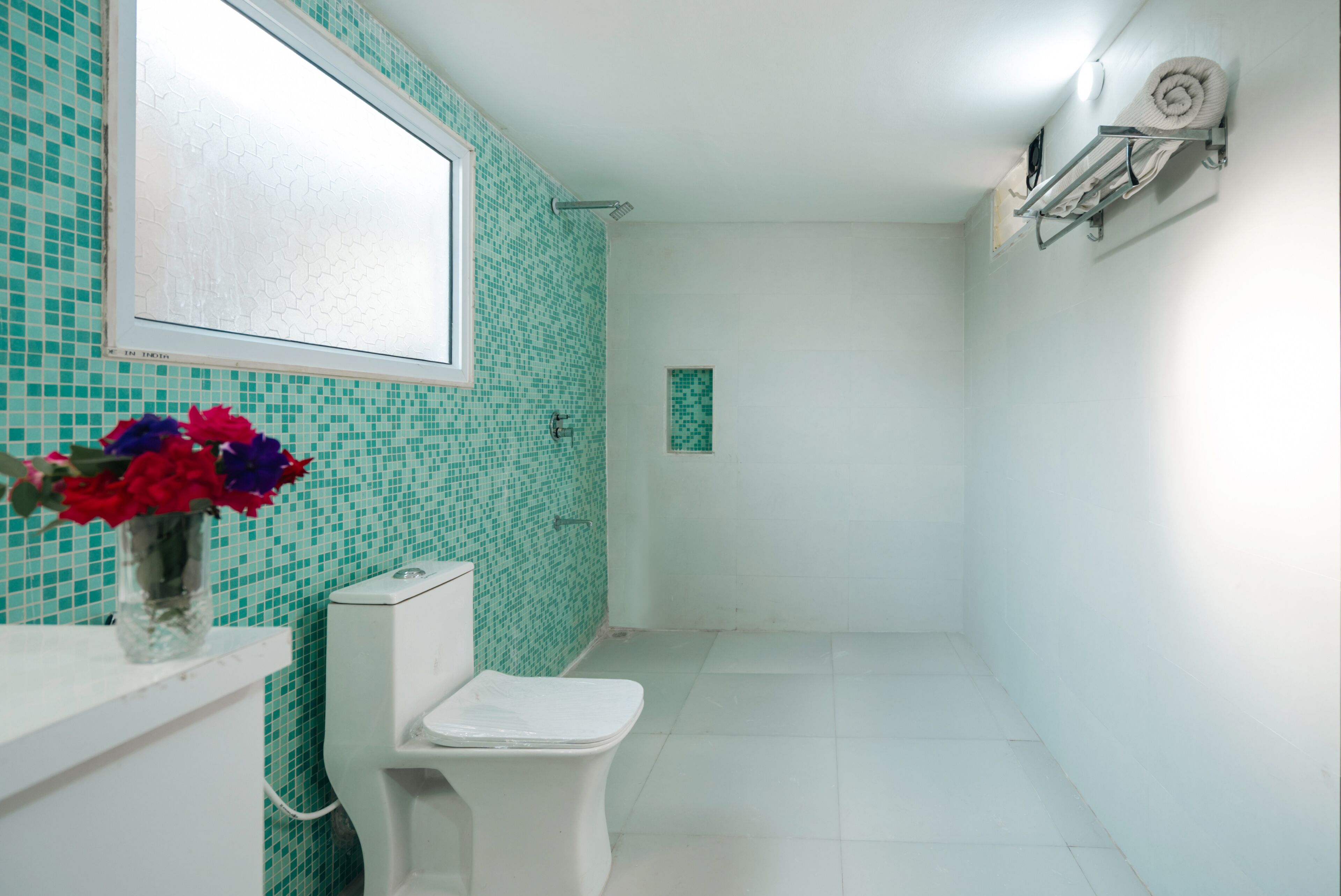 Une salle de bain comprenant des toilettes, un lavabo, un miroir et un espace douche.