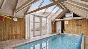 An indoor swimming pool with wooden walls and a sloped ceiling. - Lovely home in Hvide Sande with sauna (Hvide Sande)