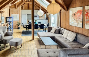 A cozy interior with a wooden ceiling, a sofa, chairs, a dining table, and artwork on the walls. - Lovely home in Hvide Sande with sauna (Hvide Sande)