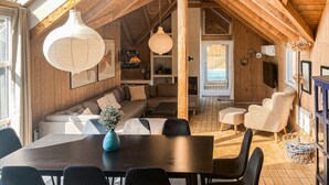 A cozy, wooden interior with a dining area, seating, and a fireplace. - Lovely home in Hvide Sande with sauna (Hvide Sande)