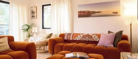 A living room with a sofa set, a chair, a table, and a lamp.