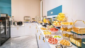 Disposición de un bufé con diversos alimentos y electrodomésticos de cocina.